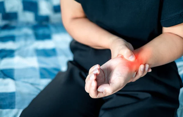 stock image Close up Woman holding wrist due to wrist injury at home, medical treatment, first aid, Healthcare and medical concept.