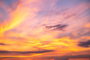 Güzel, lüks, yumuşak, turuncu, altın rengi bulutlar ve mavi gökyüzünde güneş ışığı. Arka plan için mükemmel. Alacakaranlık 'ın tadını çıkar.