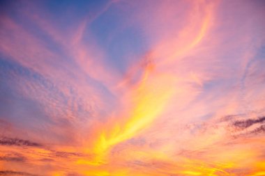 Güzel, lüks, yumuşak, turuncu, altın rengi bulutlar ve mavi gökyüzünde güneş ışığı. Arka plan için mükemmel. Alacakaranlık 'ın tadını çıkar.
