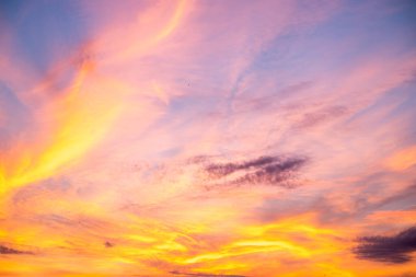 Güzel, lüks, yumuşak, turuncu, altın rengi bulutlar ve mavi gökyüzünde güneş ışığı. Arka plan için mükemmel. Alacakaranlık 'ın tadını çıkar.