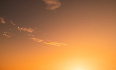 Güzel, lüks, yumuşak, turuncu, altın rengi bulutlar ve mavi gökyüzünde güneş ışığı. Arka plan için mükemmel. Alacakaranlık 'ın tadını çıkar.