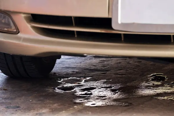 Araba parktayken araba yağı lekeleri beton zemine damlamış. Arabanın havalandırma sıvısı arabanın altına damladı, boşluğu kopyaladı.