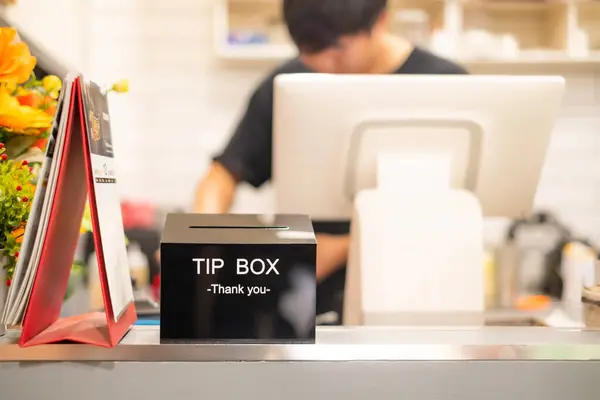 Thank you word  on Black Tip box  for good service on cashier counter in coffee shop.Tips is a sum of money customarily given by a client or customer to a service worker, in addition to the basic price