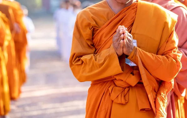 Buddhist monk is standing with his hands folded in the shape of a lotus to perform some religious ritual, uniform buddhist monk, Buddhist monk praying