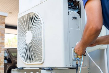 Erkek teknisyen yazın evi serinletmek için açık hava kliması kuruyor. Hava kompresörü, elektronik, sıcak yaz, yüksek sıcaklık, tropikal ülkeler