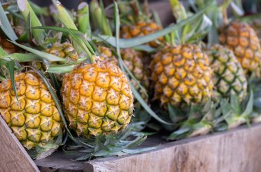 Küçük, olgun sarı ananas Ahşap rafta pek çok iştah açıcı, Tayland ananasları