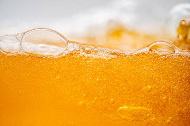 Parlak portakal yağını veya birayı kapat doku ve doğa dalgaları, güzel dalgalar eğrisi ve grafik tasarım ve arka plan için pürüzsüz küçük kabarcıklar, yağlı baloncuklar, yumuşak bira kabarcıkları, seçici odaklanma