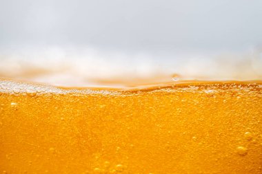 Parlak portakal yağını veya birayı kapat doku ve doğa dalgaları, güzel dalgalar eğrisi ve grafik tasarım ve arka plan için pürüzsüz küçük kabarcıklar, yağlı baloncuklar, yumuşak bira kabarcıkları, seçici odaklanma