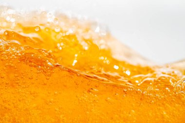 Parlak portakal yağını veya birayı kapat doku ve doğa dalgaları, güzel dalgalar eğrisi ve grafik tasarım ve arka plan için pürüzsüz küçük kabarcıklar, yağlı baloncuklar, yumuşak bira kabarcıkları, seçici odaklanma