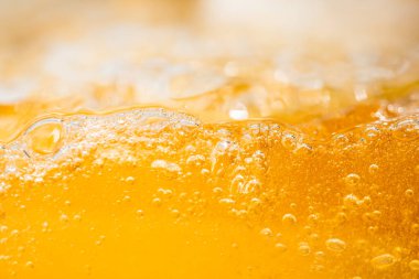 Parlak portakal yağını veya birayı kapat doku ve doğa dalgaları, güzel dalgalar eğrisi ve grafik tasarım ve arka plan için pürüzsüz küçük kabarcıklar, yağlı baloncuklar, yumuşak bira kabarcıkları, seçici odaklanma