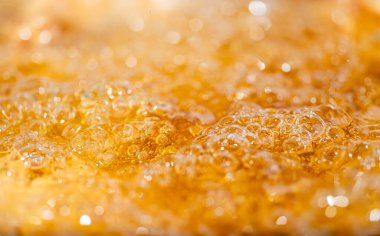 Parlak portakal yağını veya birayı kapat doku ve doğa dalgaları, güzel dalgalar eğrisi ve grafik tasarım ve arka plan için pürüzsüz küçük kabarcıklar, yağlı baloncuklar, yumuşak bira kabarcıkları, seçici odaklanma