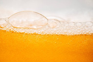 Parlak portakal yağını veya birayı kapat doku ve doğa dalgaları, güzel dalgalar eğrisi ve grafik tasarım ve arka plan için pürüzsüz küçük kabarcıklar, yağlı baloncuklar, yumuşak bira kabarcıkları, seçici odaklanma