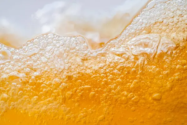 Parlak portakal yağını veya birayı kapat doku ve doğa dalgaları, güzel dalgalar eğrisi ve grafik tasarım ve arka plan için pürüzsüz küçük kabarcıklar, yağlı baloncuklar, yumuşak bira kabarcıkları, seçici odaklanma