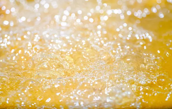 Parlak portakal yağını veya birayı kapat doku ve doğa dalgaları, güzel dalgalar eğrisi ve grafik tasarım ve arka plan için pürüzsüz küçük kabarcıklar, yağlı baloncuklar, yumuşak bira kabarcıkları, seçici odaklanma