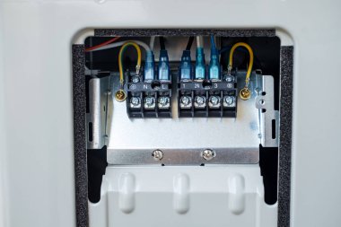 Endüstriyel bir cihazın içindeki elektrik terminali bağlantısını kapatın. Kablolar açıkça etiketlenmiş ve güvenli güç dağıtımı için topraklanmış. Teknik, endüstriyel veya mühendislik kullanımı için ideal.