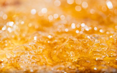 Parlak portakal yağını veya birayı kapat doku ve doğa dalgaları, güzel dalgalar eğrisi ve grafik tasarım ve arka plan için pürüzsüz küçük kabarcıklar, yağlı baloncuklar, yumuşak bira kabarcıkları, seçici odaklanma