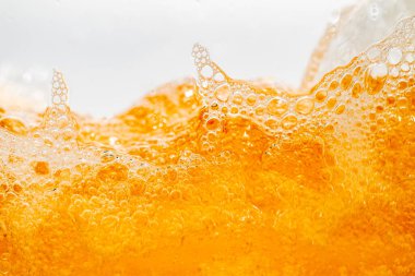 Parlak portakal yağını veya birayı kapat doku ve doğa dalgaları, güzel dalgalar eğrisi ve grafik tasarım ve arka plan için pürüzsüz küçük kabarcıklar, yağlı baloncuklar, yumuşak bira kabarcıkları, seçici odaklanma
