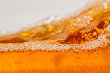 Parlak portakal yağını veya birayı kapat doku ve doğa dalgaları, güzel dalgalar eğrisi ve grafik tasarım ve arka plan için pürüzsüz küçük kabarcıklar, yağlı baloncuklar, yumuşak bira kabarcıkları, seçici odaklanma