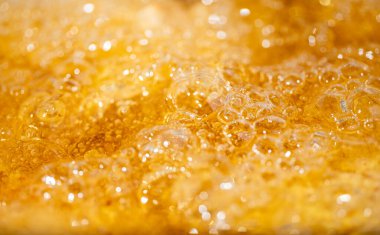 Parlak portakal yağını veya birayı kapat doku ve doğa dalgaları, güzel dalgalar eğrisi ve grafik tasarım ve arka plan için pürüzsüz küçük kabarcıklar, yağlı baloncuklar, yumuşak bira kabarcıkları, seçici odaklanma