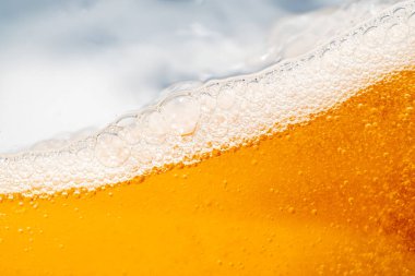 Parlak portakal yağını veya birayı kapat doku ve doğa dalgaları, güzel dalgalar eğrisi ve grafik tasarım ve arka plan için pürüzsüz küçük kabarcıklar, yağlı baloncuklar, yumuşak bira kabarcıkları, seçici odaklanma