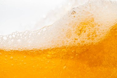 Parlak portakal yağını veya birayı kapat doku ve doğa dalgaları, güzel dalgalar eğrisi ve grafik tasarım ve arka plan için pürüzsüz küçük kabarcıklar, yağlı baloncuklar, yumuşak bira kabarcıkları, seçici odaklanma
