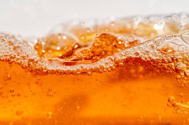 Parlak portakal yağını veya birayı kapat doku ve doğa dalgaları, güzel dalgalar eğrisi ve grafik tasarım ve arka plan için pürüzsüz küçük kabarcıklar, yağlı baloncuklar, yumuşak bira kabarcıkları, seçici odaklanma