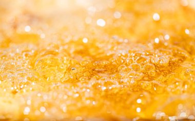 Parlak portakal yağını veya birayı kapat doku ve doğa dalgaları, güzel dalgalar eğrisi ve grafik tasarım ve arka plan için pürüzsüz küçük kabarcıklar, yağlı baloncuklar, yumuşak bira kabarcıkları, seçici odaklanma