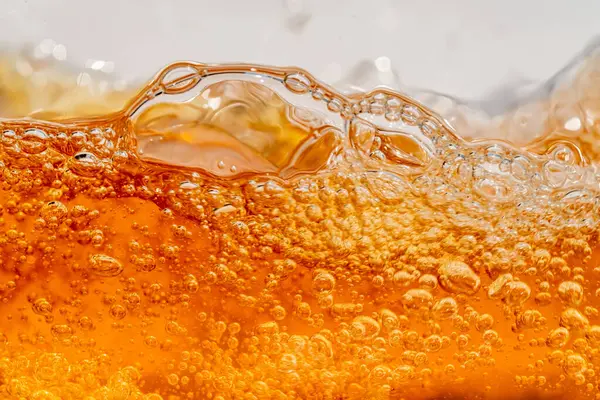 Parlak portakal yağını veya birayı kapat doku ve doğa dalgaları, güzel dalgalar eğrisi ve grafik tasarım ve arka plan için pürüzsüz küçük kabarcıklar, yağlı baloncuklar, yumuşak bira kabarcıkları, seçici odaklanma