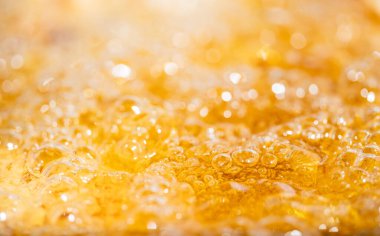 Parlak portakal yağını veya birayı kapat doku ve doğa dalgaları, güzel dalgalar eğrisi ve grafik tasarım ve arka plan için pürüzsüz küçük kabarcıklar, yağlı baloncuklar, yumuşak bira kabarcıkları, seçici odaklanma