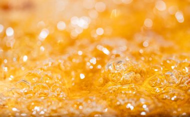 Parlak portakal yağını veya birayı kapat doku ve doğa dalgaları, güzel dalgalar eğrisi ve grafik tasarım ve arka plan için pürüzsüz küçük kabarcıklar, yağlı baloncuklar, yumuşak bira kabarcıkları, seçici odaklanma