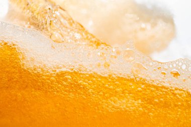 Parlak portakal yağını veya birayı kapat doku ve doğa dalgaları, güzel dalgalar eğrisi ve grafik tasarım ve arka plan için pürüzsüz küçük kabarcıklar, yağlı baloncuklar, yumuşak bira kabarcıkları, seçici odaklanma