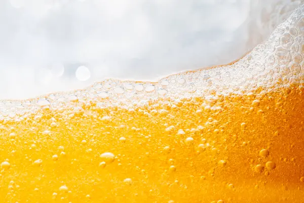 Parlak portakal yağını veya birayı kapat doku ve doğa dalgaları, güzel dalgalar eğrisi ve grafik tasarım ve arka plan için pürüzsüz küçük kabarcıklar, yağlı baloncuklar, yumuşak bira kabarcıkları, seçici odaklanma