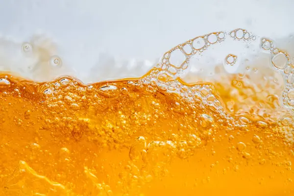 Parlak portakal yağını veya birayı kapat doku ve doğa dalgaları, güzel dalgalar eğrisi ve grafik tasarım ve arka plan için pürüzsüz küçük kabarcıklar, yağlı baloncuklar, yumuşak bira kabarcıkları, seçici odaklanma