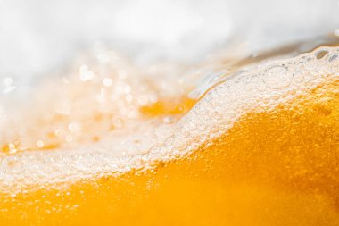 Parlak portakal yağını veya birayı kapat doku ve doğa dalgaları, güzel dalgalar eğrisi ve grafik tasarım ve arka plan için pürüzsüz küçük kabarcıklar, yağlı baloncuklar, yumuşak bira kabarcıkları, seçici odaklanma