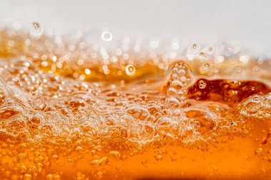 Parlak portakal yağını veya birayı kapat doku ve doğa dalgaları, güzel dalgalar eğrisi ve grafik tasarım ve arka plan için pürüzsüz küçük kabarcıklar, yağlı baloncuklar, yumuşak bira kabarcıkları, seçici odaklanma