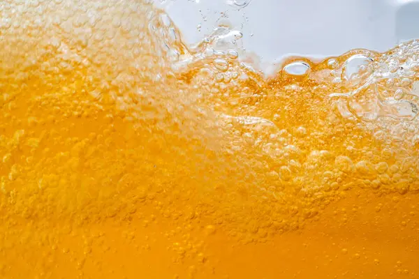 Parlak portakal yağını veya birayı kapat doku ve doğa dalgaları, güzel dalgalar eğrisi ve grafik tasarım ve arka plan için pürüzsüz küçük kabarcıklar, yağlı baloncuklar, yumuşak bira kabarcıkları, seçici odaklanma