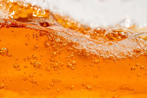 Parlak portakal yağını veya birayı kapat doku ve doğa dalgaları, güzel dalgalar eğrisi ve grafik tasarım ve arka plan için pürüzsüz küçük kabarcıklar, yağlı baloncuklar, yumuşak bira kabarcıkları, seçici odaklanma