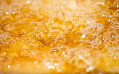 Parlak portakal yağını veya birayı kapat doku ve doğa dalgaları, güzel dalgalar eğrisi ve grafik tasarım ve arka plan için pürüzsüz küçük kabarcıklar, yağlı baloncuklar, yumuşak bira kabarcıkları, seçici odaklanma