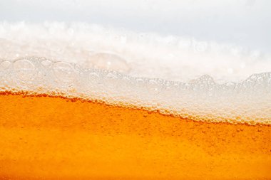 Parlak portakal yağını veya birayı kapat doku ve doğa dalgaları, güzel dalgalar eğrisi ve grafik tasarım ve arka plan için pürüzsüz küçük kabarcıklar, yağlı baloncuklar, yumuşak bira kabarcıkları, seçici odaklanma