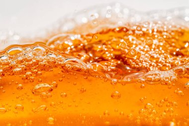 Parlak portakal yağını veya birayı kapat doku ve doğa dalgaları, güzel dalgalar eğrisi ve grafik tasarım ve arka plan için pürüzsüz küçük kabarcıklar, yağlı baloncuklar, yumuşak bira kabarcıkları, seçici odaklanma