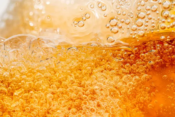 Parlak portakal yağını veya birayı kapat doku ve doğa dalgaları, güzel dalgalar eğrisi ve grafik tasarım ve arka plan için pürüzsüz küçük kabarcıklar, yağlı baloncuklar, yumuşak bira kabarcıkları, seçici odaklanma