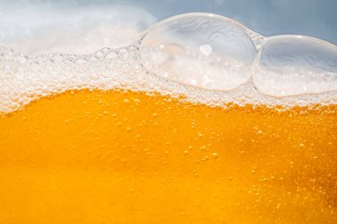 Parlak portakal yağını veya birayı kapat doku ve doğa dalgaları, güzel dalgalar eğrisi ve grafik tasarım ve arka plan için pürüzsüz küçük kabarcıklar, yağlı baloncuklar, yumuşak bira kabarcıkları, seçici odaklanma