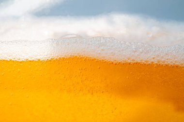 Parlak portakal yağını veya birayı kapat doku ve doğa dalgaları, güzel dalgalar eğrisi ve grafik tasarım ve arka plan için pürüzsüz küçük kabarcıklar, yağlı baloncuklar, yumuşak bira kabarcıkları, seçici odaklanma