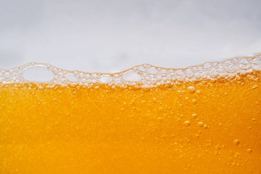 Parlak portakal yağını veya birayı kapat doku ve doğa dalgaları, güzel dalgalar eğrisi ve grafik tasarım ve arka plan için pürüzsüz küçük kabarcıklar, yağlı baloncuklar, yumuşak bira kabarcıkları, seçici odaklanma