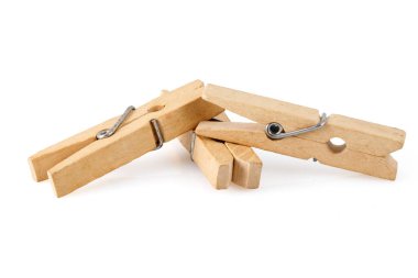 Beyaz arka planda izole edilmiş üç tahta mandal yan yana yatıyor. Fotoğrafı kapat. Tam alan derinliği.