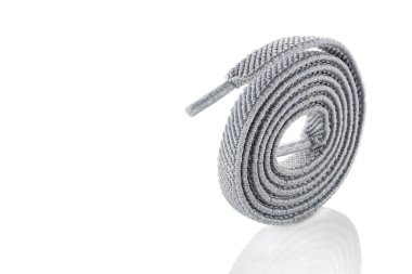 Açık gri kumaş bağcıkları beyaz arkaplanda izole edilmiş. Kapatın. Şık aksesuar.