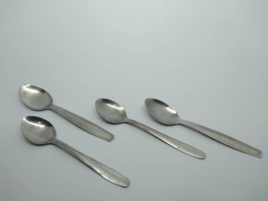 small metal spoons arranged on a white background