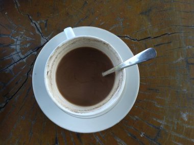 Beyaz seramik fincan, içinde kaşık ve kalan kahve.