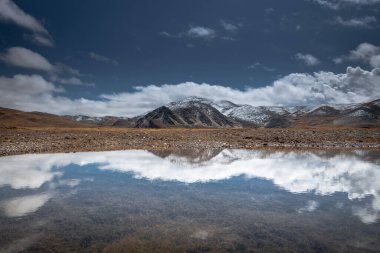 Bulutlu havada karlı dağ deresi.