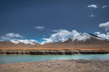 Bulutlu havada karlı dağ deresi.